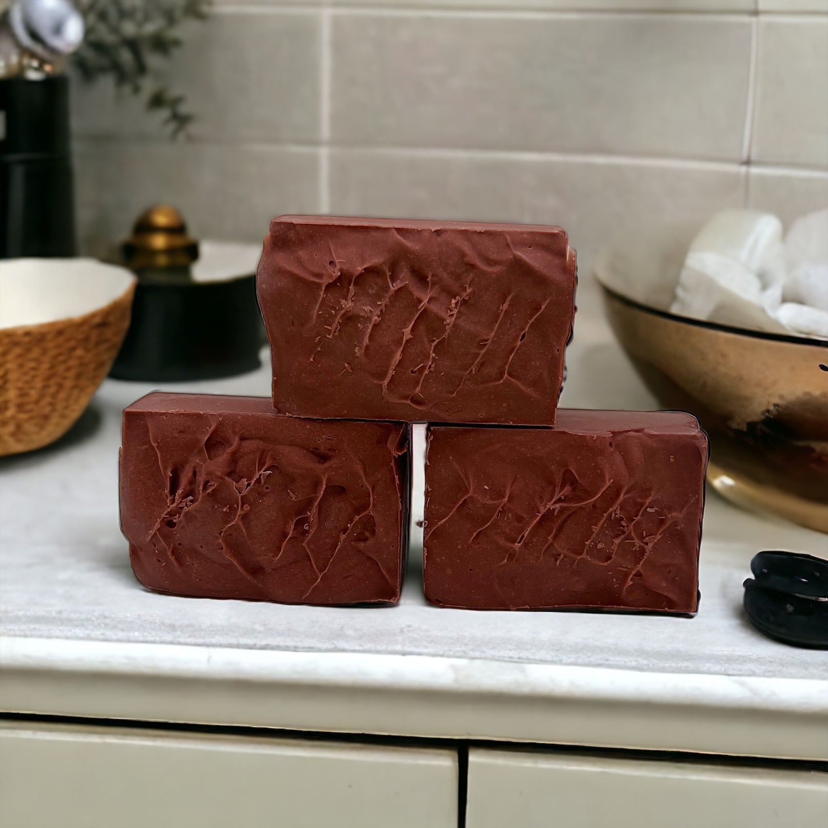 Three handcrafted soap bars stacked with a textured creamy surface.