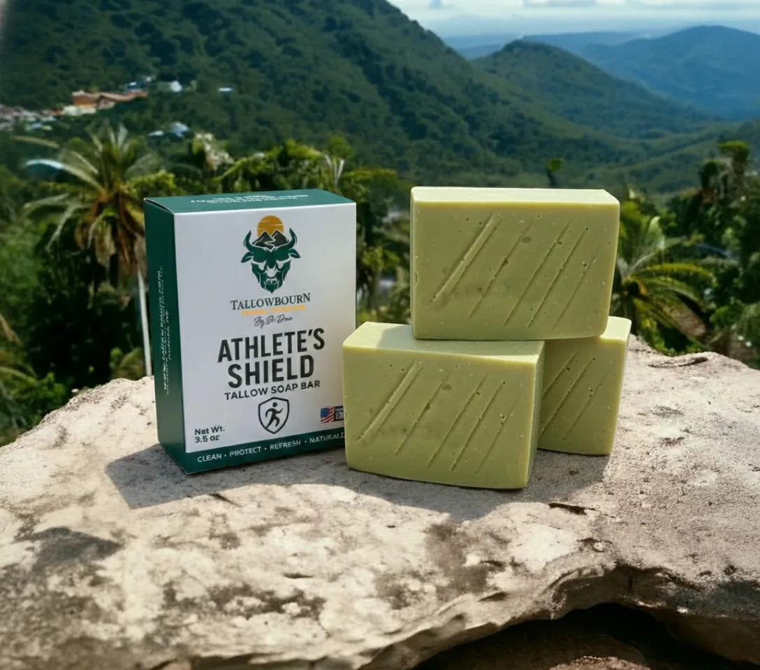 Tallowbourn Athlete's Shield soap bars and packaging on a rock with a mountainous background